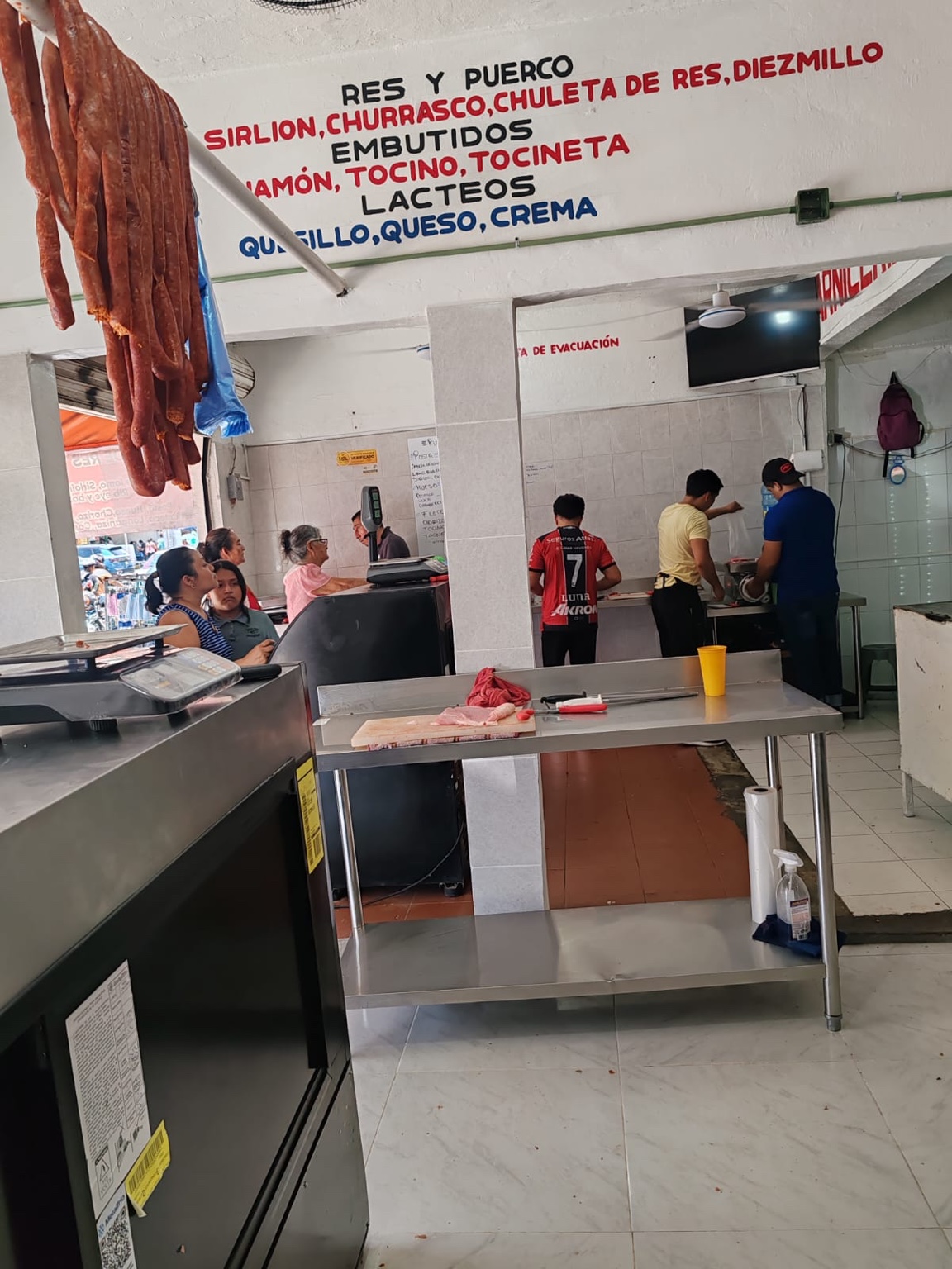 Interior de Carnicería Susy con letreros de cortes y productos